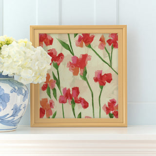a framed painting of red flowers on a white background, placed on a shelf next to a blue and white vase filled with white hydrangeas.