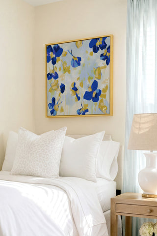 a well-decorated bedroom with a large floral painting hanging on the wall above a bed with white bedding and pillows.