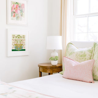 a cozy bedroom corner with a bed, a wooden nightstand, and a framed artwork on the wall.