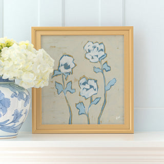 a framed painting of blue flowers on a white shelf, accompanied by a vase of white hydrangeas.